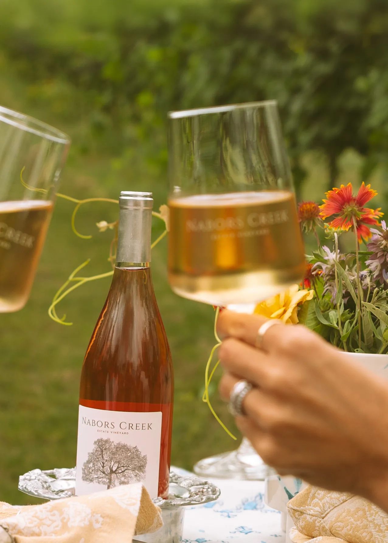 Two people raising a toast during a private event for two in the vineyard.