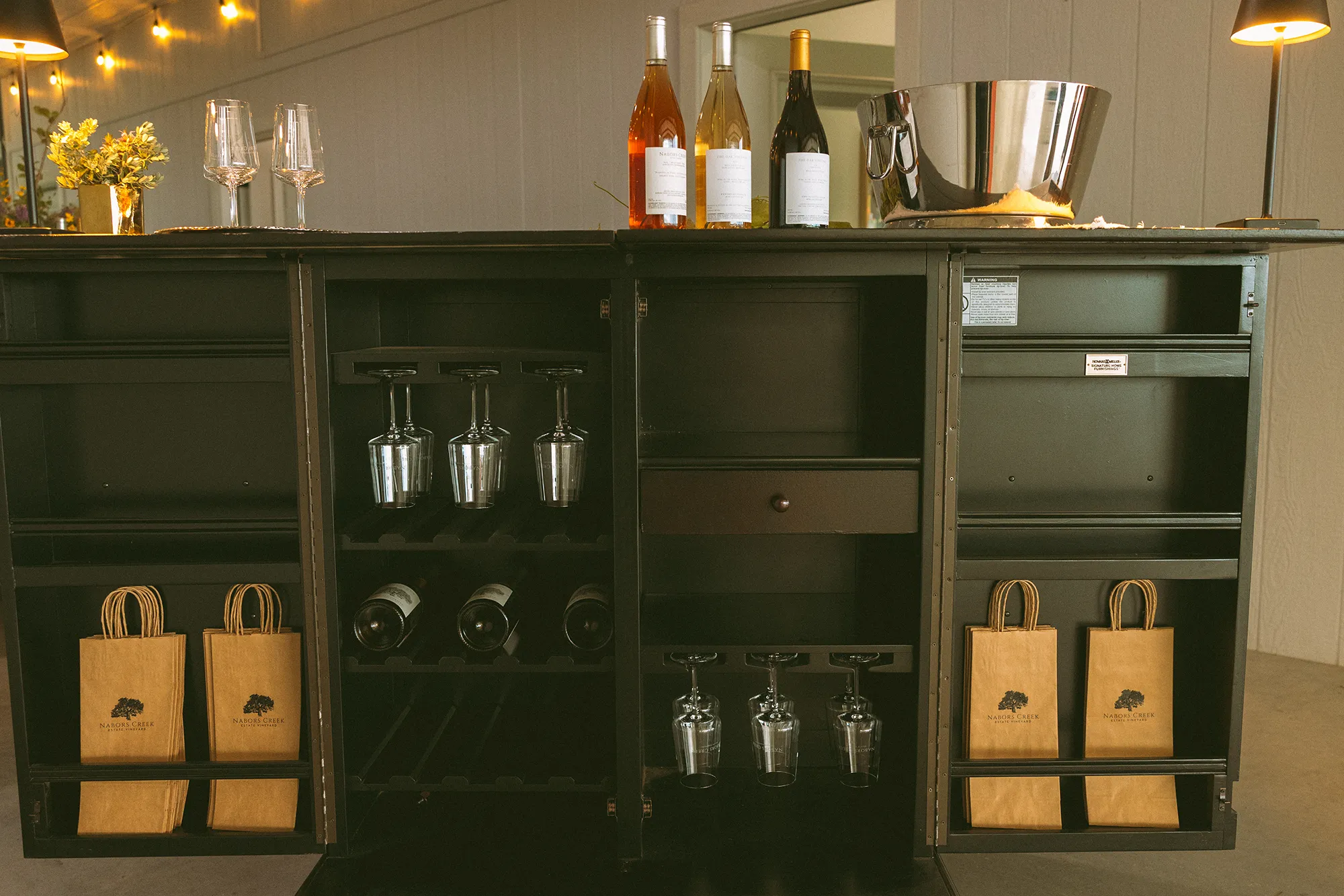 Storage area with Nabors creek wine, glasses and bags